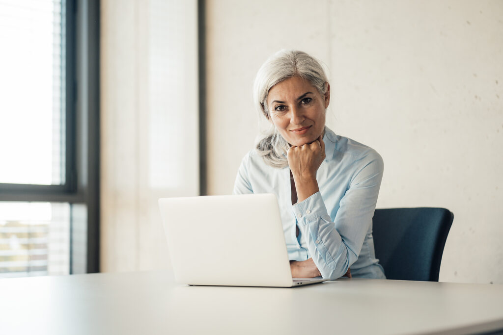 Lächelnde Geschäftsfrau mit Laptop sitzt am Schreibtisch im Büro Lizenzfreies Stockfoto Lächelnde Geschäftsfrau mit Laptop sitzt am Schreibtisch im Büro
Lizenzfreies Stockfoto