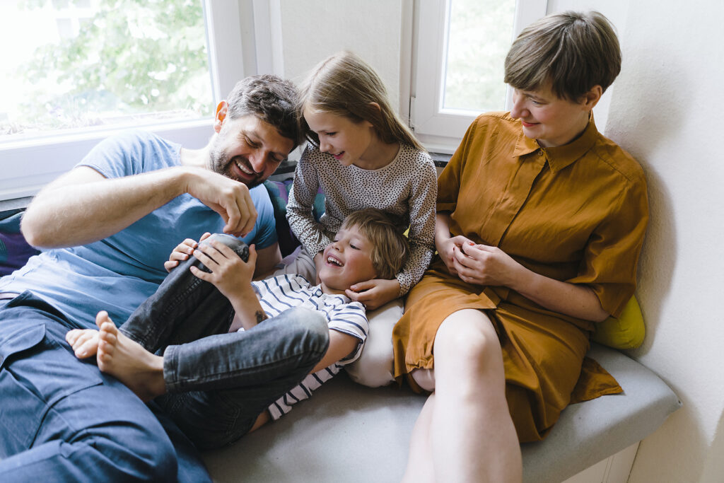 Verspielte Familie, die zu Hause sitzt und miteinander Spaß hat Lizenzfreies Stockfoto Verspielte Familie, die zu Hause sitzt und miteinander Spaß hat
Lizenzfreies Stockfoto