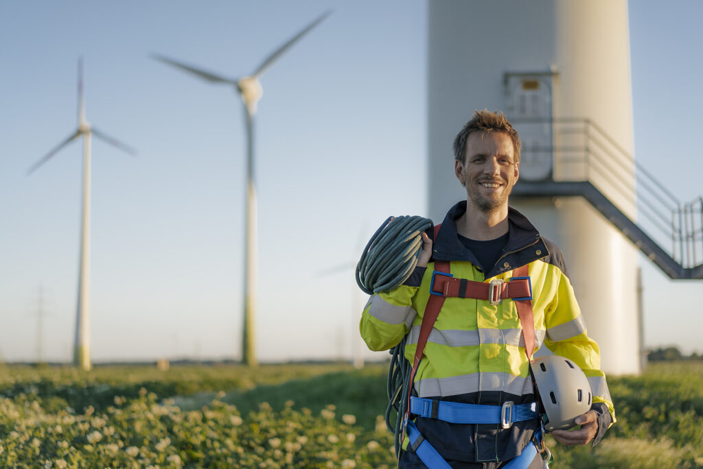Portrait of smiling technician standing at a wind farm with climbing equipment Royalty-free image Portrait of smiling technician standing at a wind farm with climbing equipment
Royalty-free image