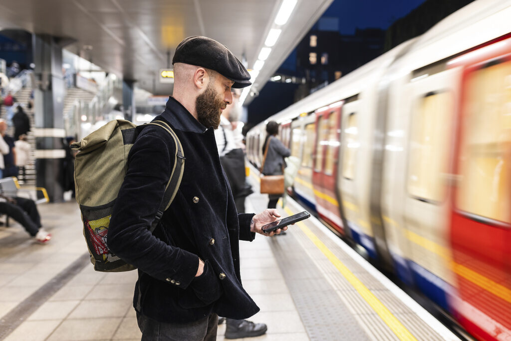 Man using smart phone standing near moving train at station Royalty-free image Man using smart phone standing near moving train at station
Royalty-free image