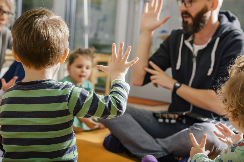 Child raising hand while singing with others and teacher in kindergarten Royalty-free image Child raising hand while singing with others and teacher in kindergarten
Royalty-free image