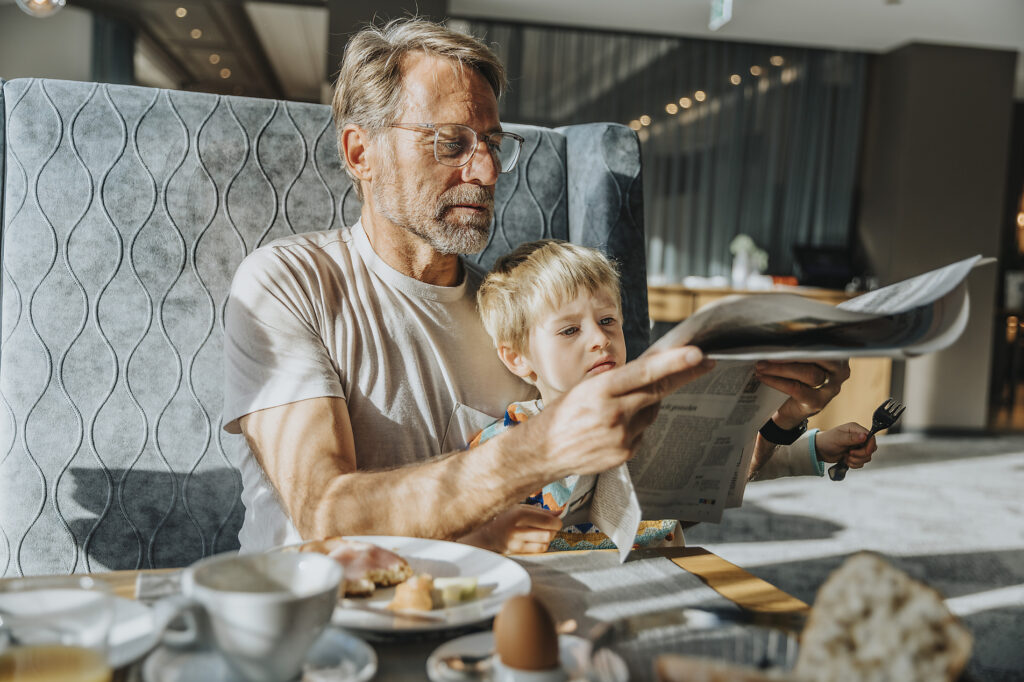 Älterer Mann mit Sohn liest Zeitung, während er am Tisch im Hotelzimmer sitzt Lizenzfreies Stockfoto Älterer Mann mit Sohn liest Zeitung, während er am Tisch im Hotelzimmer sitzt
Lizenzfreies Stockfoto