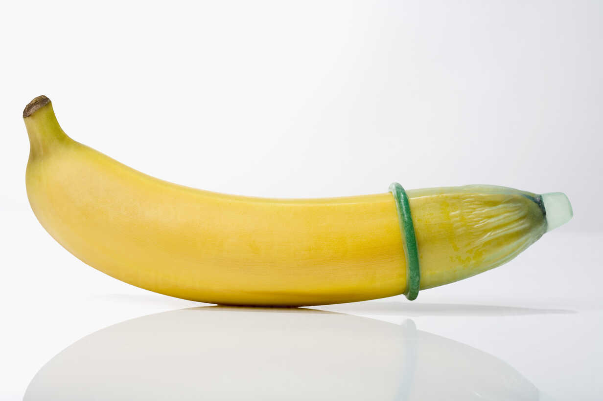 Condom on banana, close-up stock photo
