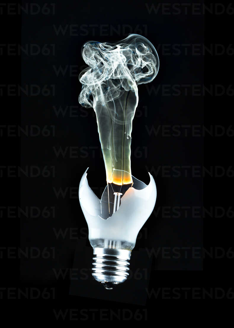 Furning light bulb against black background, close up stock photo