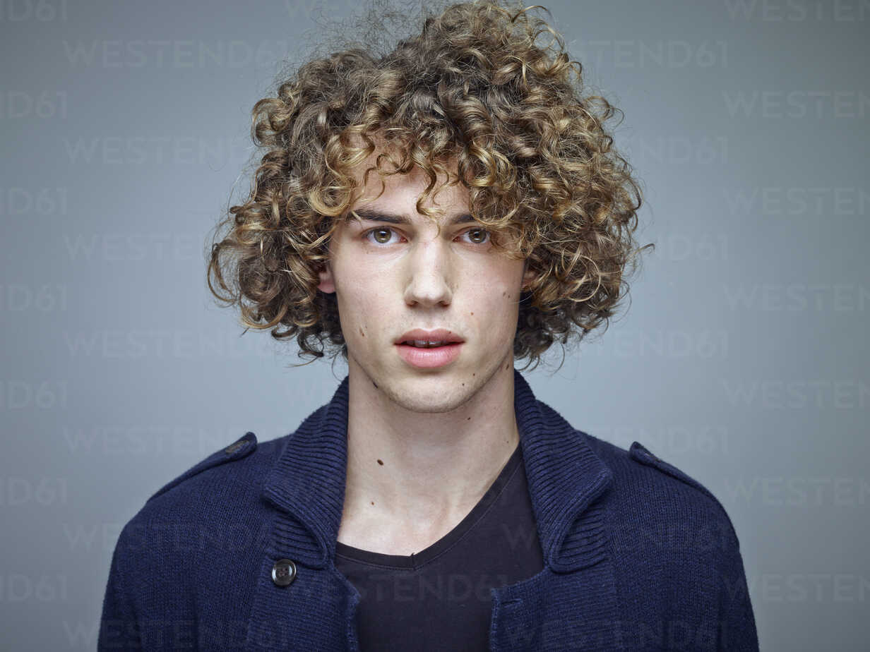 Portrait of young man with curly blond hair stock photo