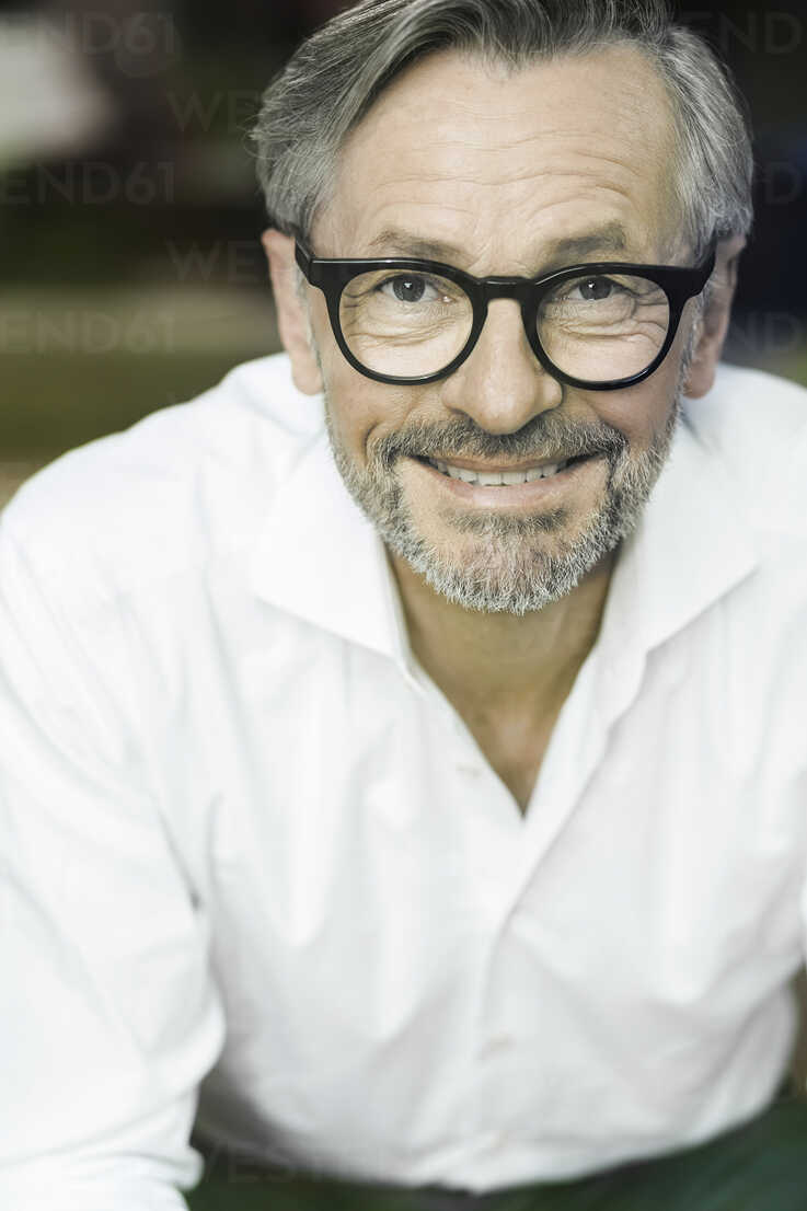 Portrait of smiling man with grey hair and beard wearing spectacles stock  photo