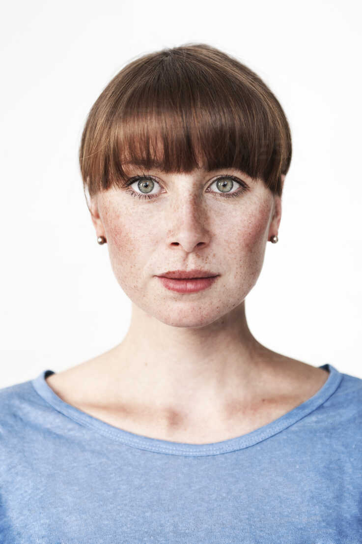 Biometric passport photo of a green-eyed read-haired woman with freckles  and bangs stock photo