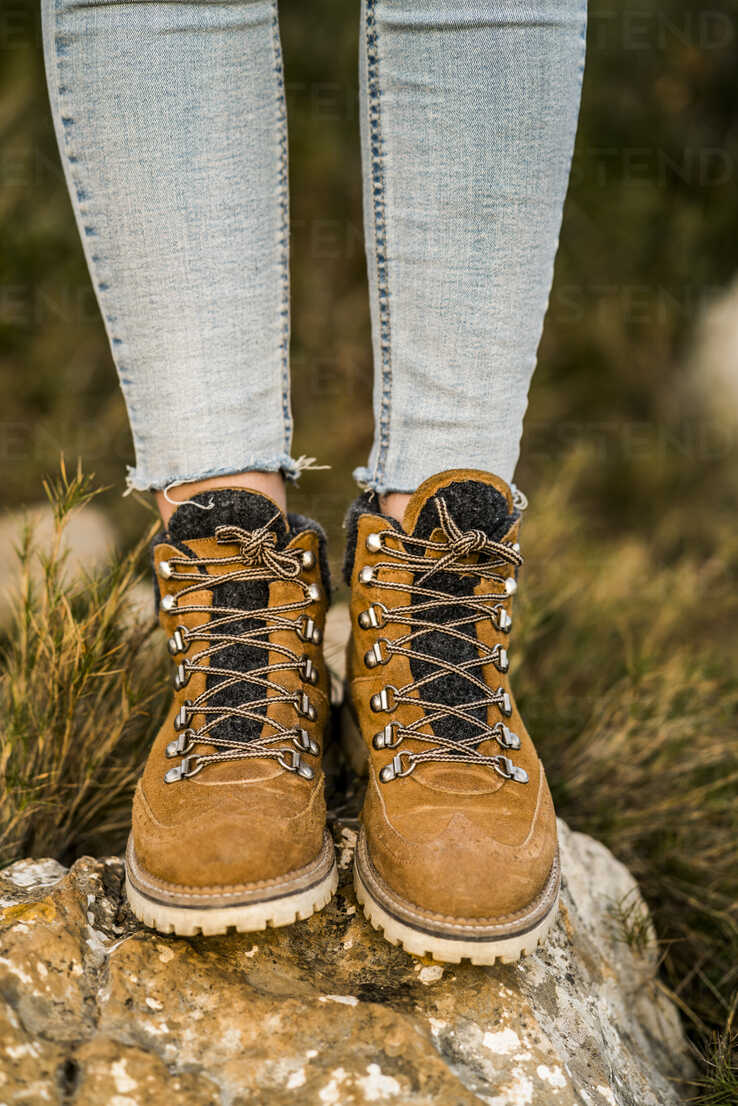 Woman wearing hiking boots standing on a rock stock photo