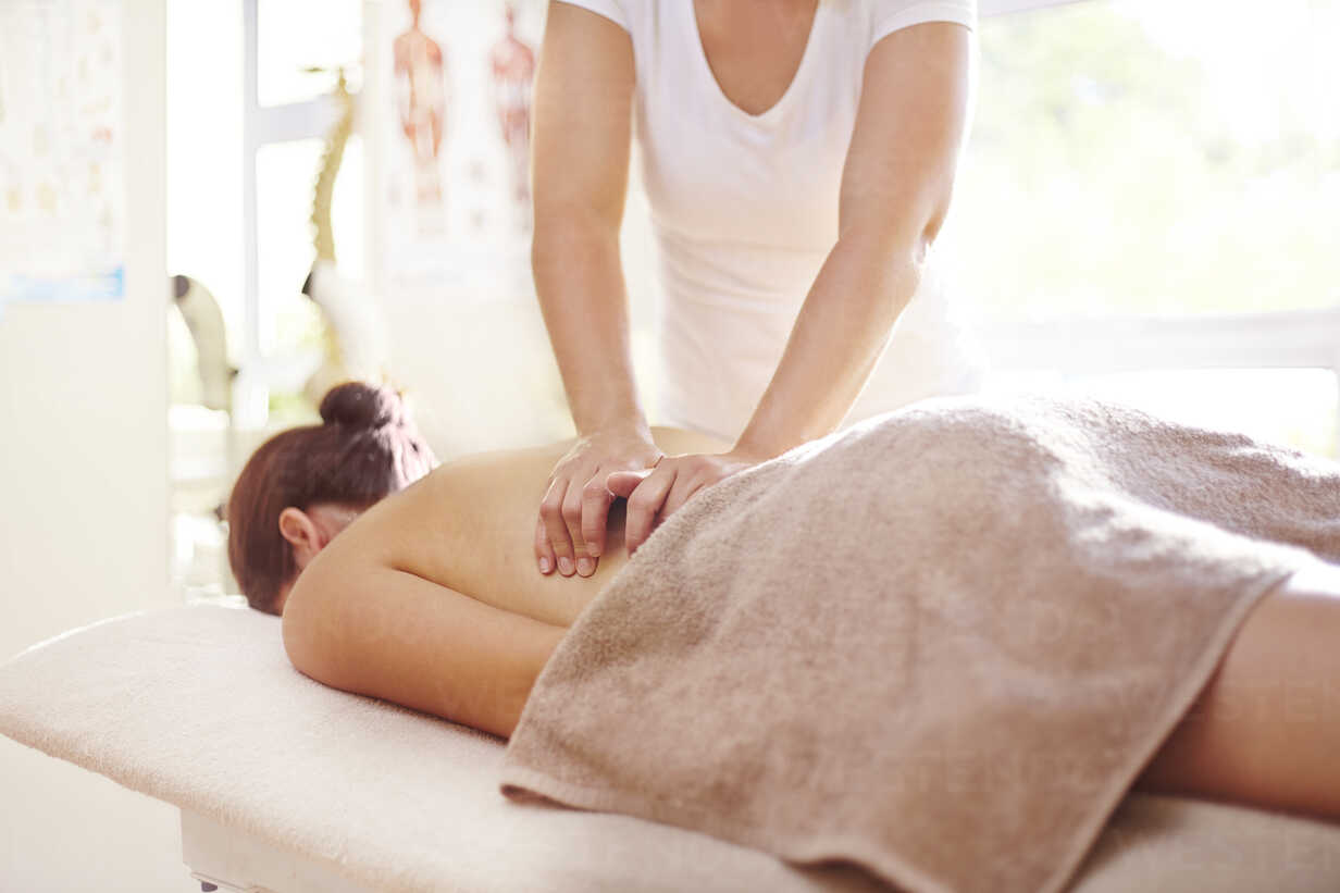 Woman receiving massage by masseuse stock photo
