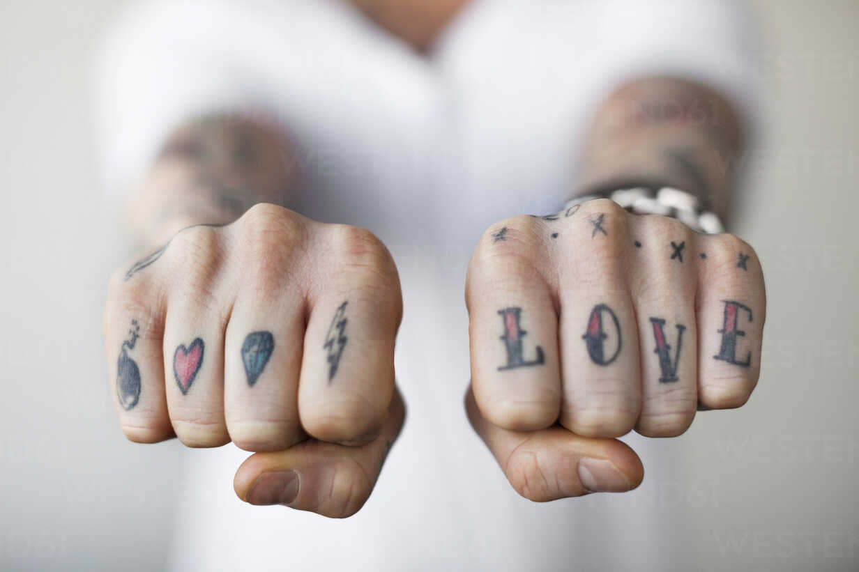 Mid section of a man showing love tattoos on his punch stock photo