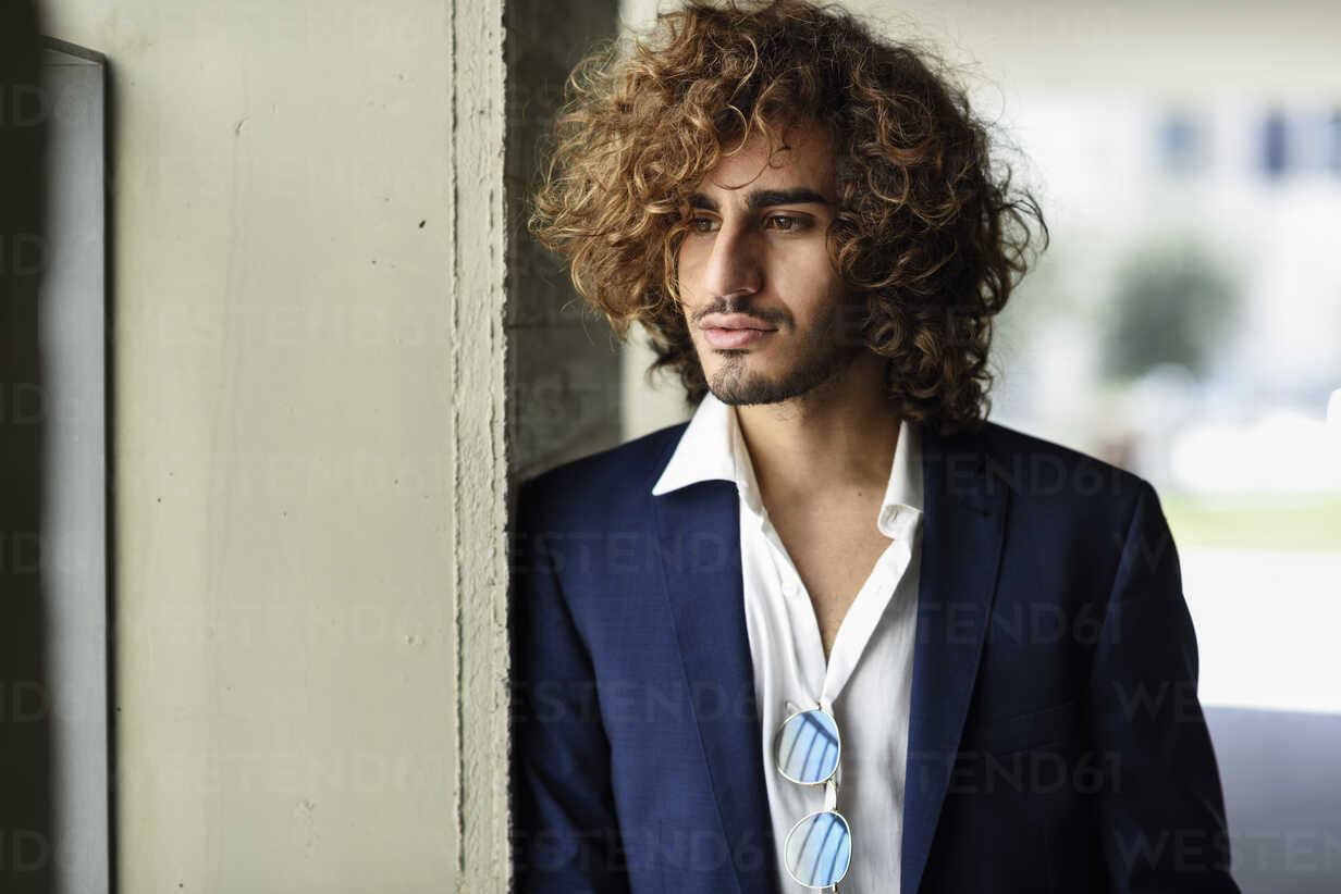 Portrait of stylish young man with beard and curly hair stock photo