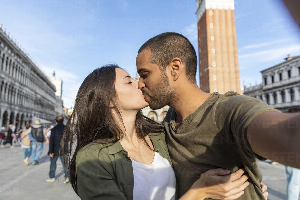 Italy, Venice, selfie of tourist couple kissing on St Mark's Square stock  photo