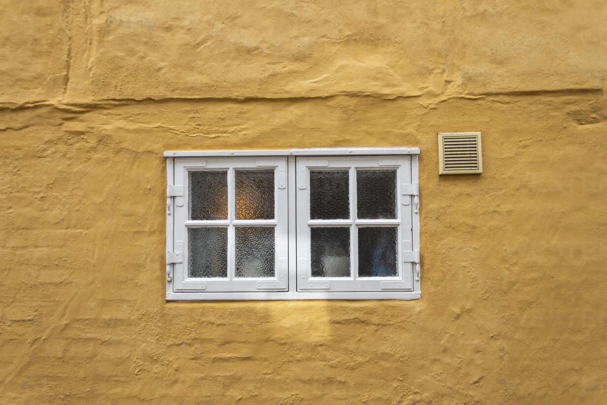 Denmark, Ribe, Small paned windows in yellow house wall stock photo