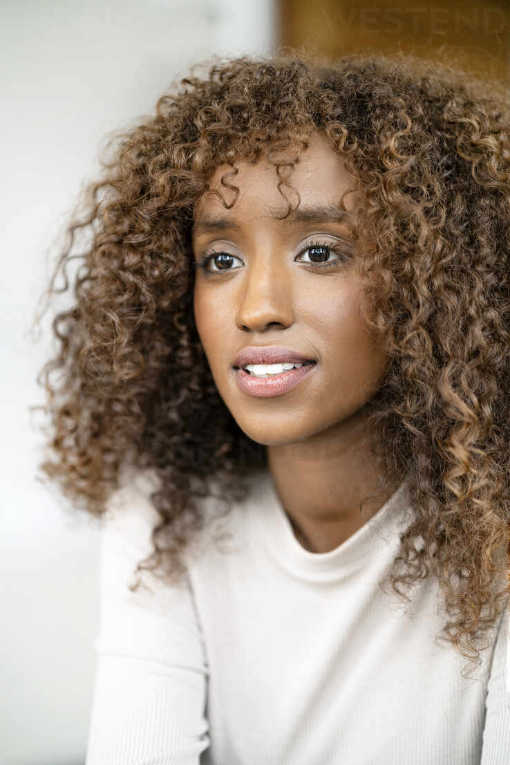 Close-up of thoughtful businesswoman with curly hair in office stock photo