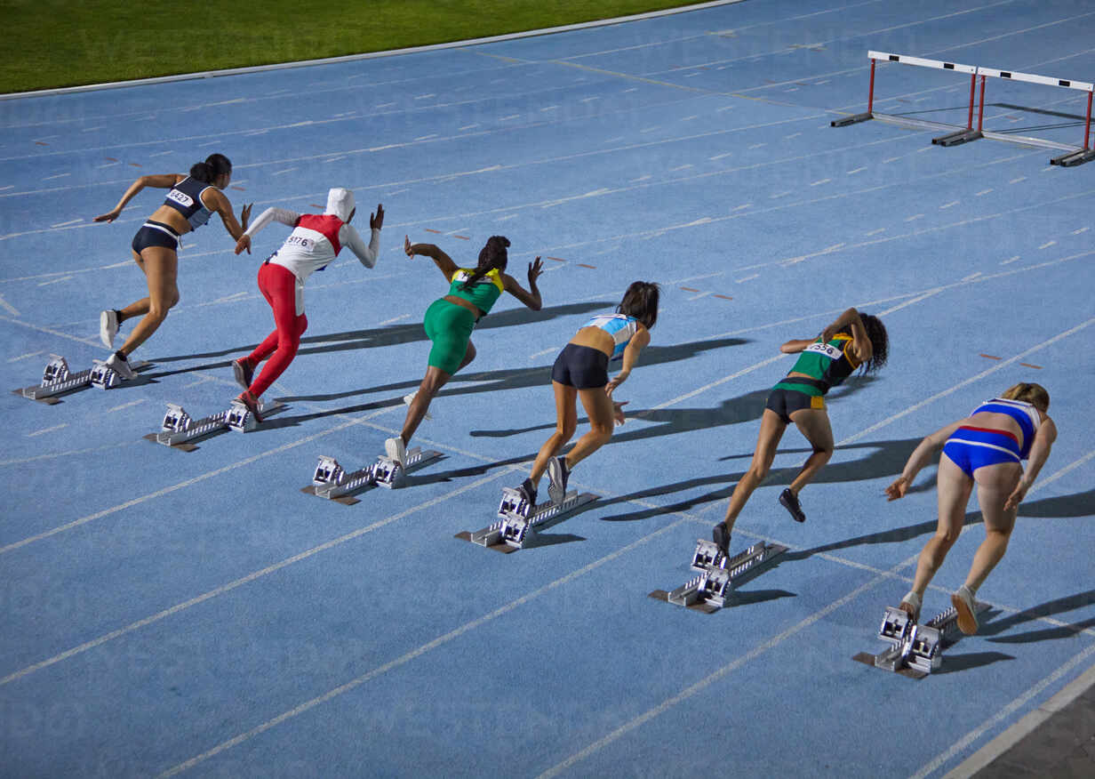 Female track and field athletes at starting blocks stock photo